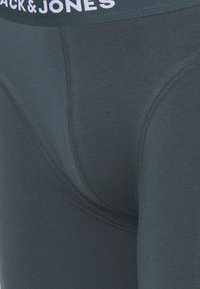 Dunkelgraue Modal-Mix-Boxershorts mit einer glatten Textur, ausgestattet mit einem grünen elastischen Taillenbund mit dem weißen Logo "BLACK & JONES".