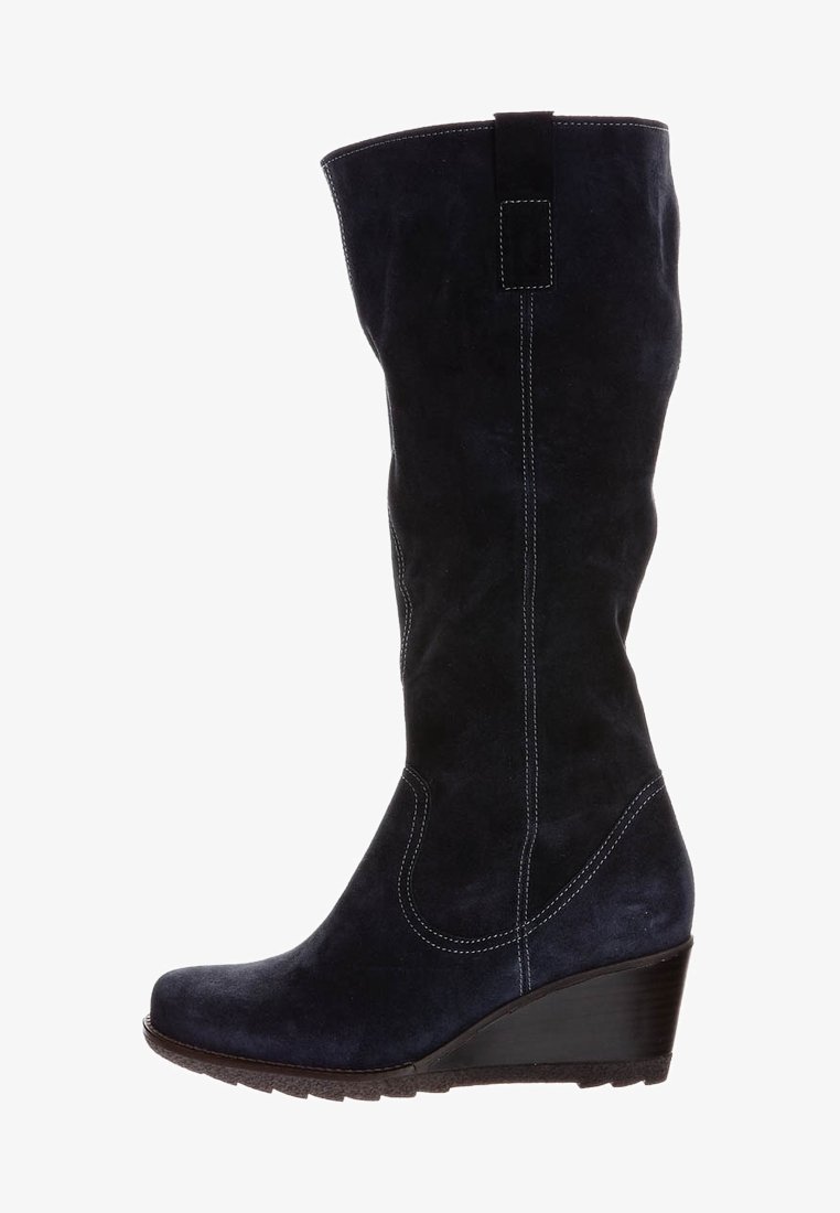 Bota de ante azul marino hasta la rodilla con tacón cuña, costuras en blanco que contrastan y un panel decorativo en la parte trasera. Textura suave, puntera redondeada.