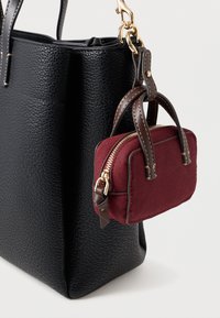Μαύρη τσάντα tote από υφαντό δέρμα με μικρή μαρόν βελούδινη θήκη που είναι προσαρτημένη, διαθέτει χρυσό φερμουάρ και καφέ δερμάτινες λεπτομέρειες.