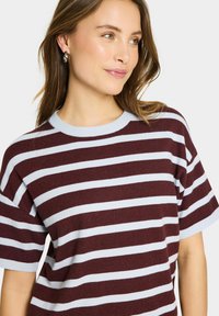 Pulover rayat în nuanțe de bordeux și albastru deschis, cu guler rotund, mâneci scurte și o textură moale. Design modern, cu o croială relaxată.