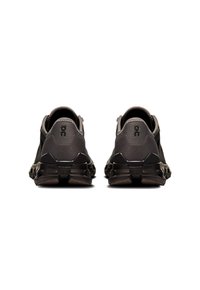 Black athletic shoes with a textured upper, distinct heel design, and visible logo. Featuring rubber soles for grip and durability.