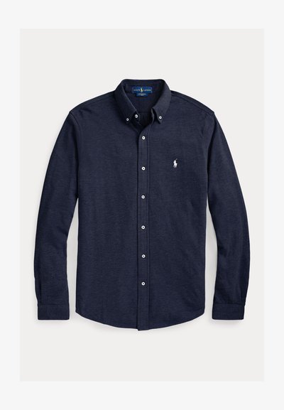 Tamnoplava košulja dugih rukava s gumbima, ovratnik s gumbima i malim bijelim izvezenim logom na lijevoj strani prsa.