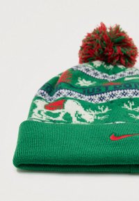 Gorro de malha verde com um pom-pom vermelho, padrões temáticos de Natal e um pequeno logotipo vermelho da Nike na bainha.