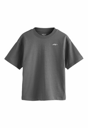 Harmaa puuvillainen T-paita lyhyillä hihoilla, ribattu pyöreä kaula-aukko ja pieni valkoinen logo vasemmassa rinnassa. Sujuva pinta, rento muotoilu.