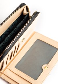 Portafoglio in pelle sintetica beige con zip nera, dotato di più slot per carte, una finestra per ID trasparente e un interno con motivo scuro.