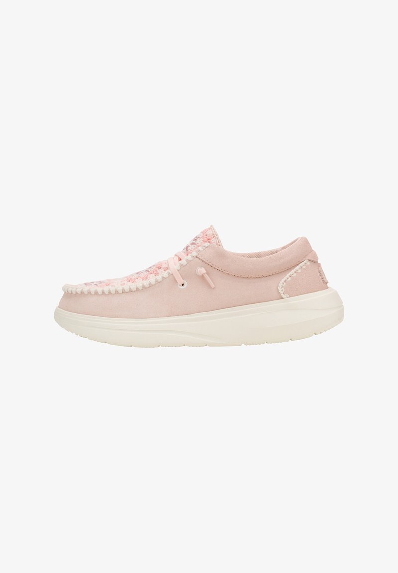 Zapato de ante rosa claro con acentos decorativos trenzados, costuras blancas, punta redondeada y una suela blanca gruesa para mayor comodidad.