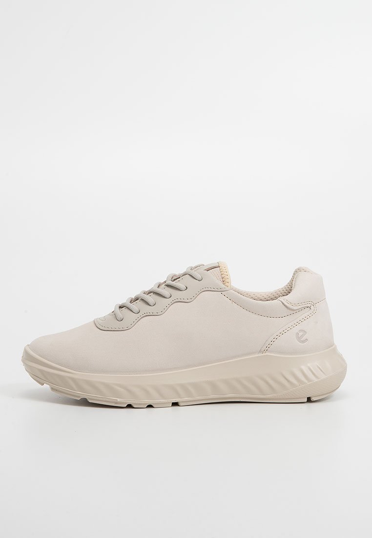 Beżowe sportowe trampki z sznurowaniem z przodu, wyściełanym kołnierzem, teksturowaną podeszwą i subtelnym logo na pięcie, umieszczone na białym tle.