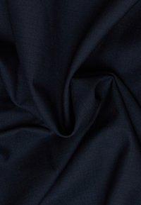 Tessuto di un blu navy scuro con una piega centrale intrecciata, che mostra una trama testurizzata e una caduta morbida.