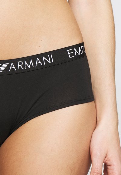Black underwear with a smooth texture, featuring a wide elastic waistband. The waistband has "EMPORIO ARMANI" in white lettering.