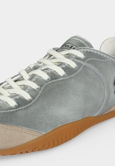 Baskets en cuir gris avec lacets blancs, bout en daim beige et semelle en caoutchouc marron vues de côté et de dessus.