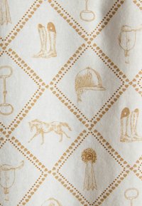 Equestrian-themed pattern with illustrations of riding boots, horse, helmet, trophies, and ribbons in a diamond grid on fabric.