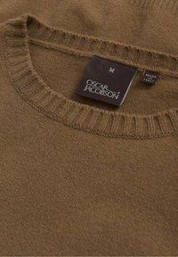 Pull marron en tricot avec un col rond. L'étiquette indique "Oscar Jacobson", taille M, et "Fabriqué en Italie". La texture semble douce avec un col côtelé.