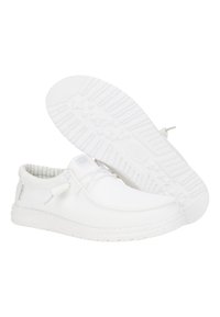 Weiße Slippers aus einem strukturierten Mesh-Material, mit einer flachen Gummisohle mit Sternmustern und minimalistischen Schnürdetails.