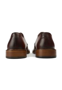 Brown leather shoes with a smooth finish, low heel, and round toe. Features contrasting stitched details and a wooden sole.