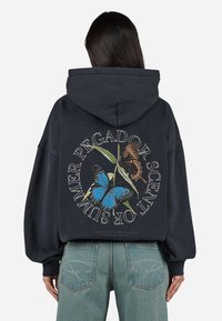 Donker hoodie met een grote vlinderafbeelding op de achterkant. Heeft een trekkoordkap, geribde manchetten en een relaxte pasvorm.