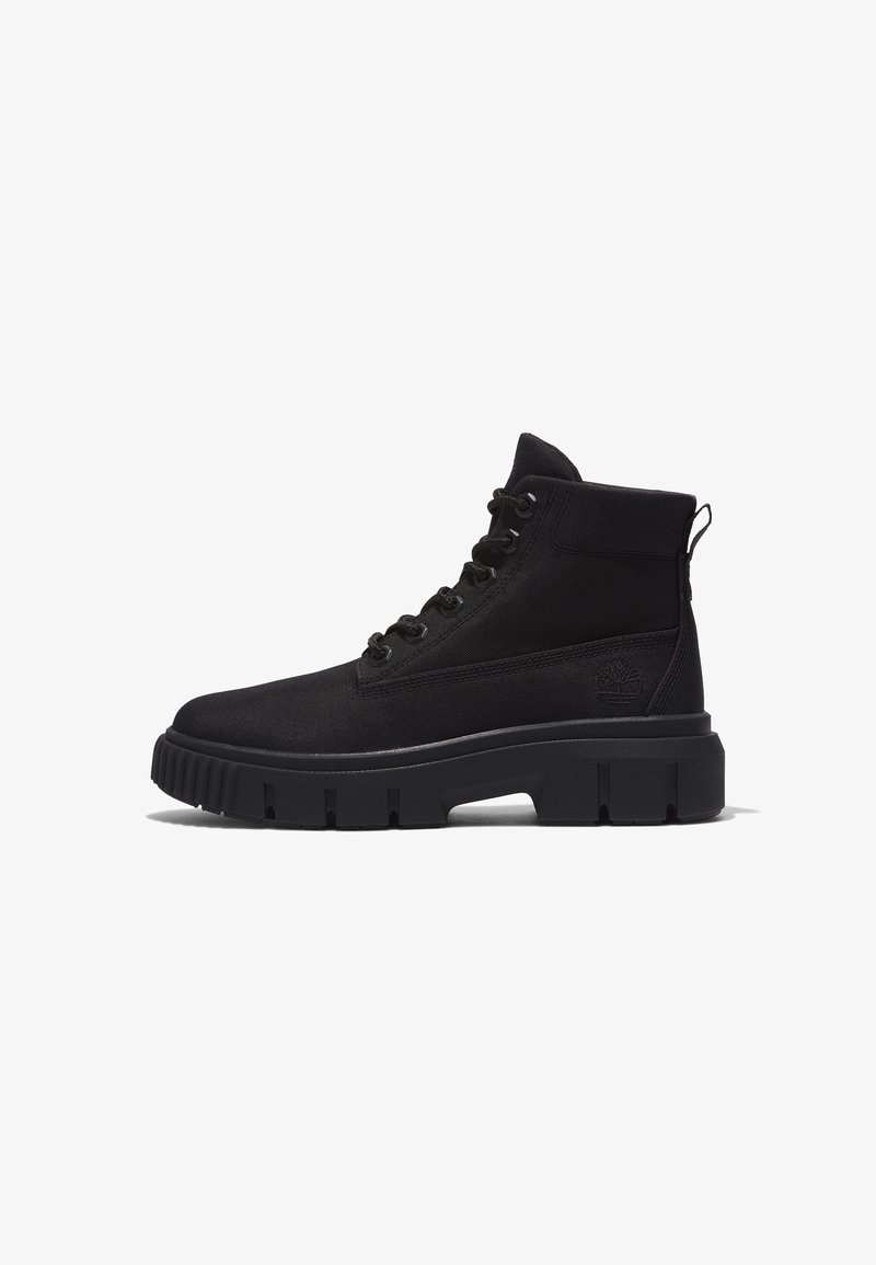 Botte montante noire à lacets avec semelle épaisse en caoutchouc et languette à l'arrière, présentant une tige en tissu texturé et un logo discret sur le côté.