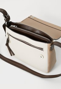 Borsa in pelle color tortora e crema con forma strutturata, scomparti con zip e tracolla marrone. Presenta cuciture bianche e un tirazip decorativo.