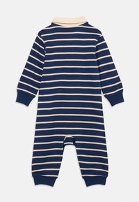Combinaison pour bébé à rayures navy et beige, à manches longues, avec col et poignets côtelés sur les manches et les chevilles, vue de dos.
