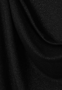 Sort stof med en glat, let skinnende overflade, der har et subtilt metallic prikket mønster. Nærbillede, der fremhæver fald og finish.