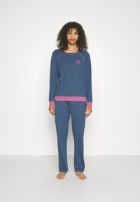 Comfortabele blauwe pyjama set gemaakt van zachte stof. Heeft lange mouwen, gestreepte roze accenten en een klein hart ontwerp op de borst.