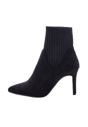 Stivale alla caviglia in suede nero con punta a punta, sopra in maglia a coste e tacco alto sottile.