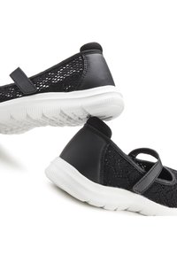 Black shoes featuring a mesh lace upper with a leather heel and strap, paired with a white rubber outsole for traction.