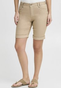 Pantalones cortos de mezclilla beige con pu�ños enrollados, diseño de cinco bolsillos y cierre de botón de metal. Fabricados con tejido elástico para mayor comodidad y ajuste.
