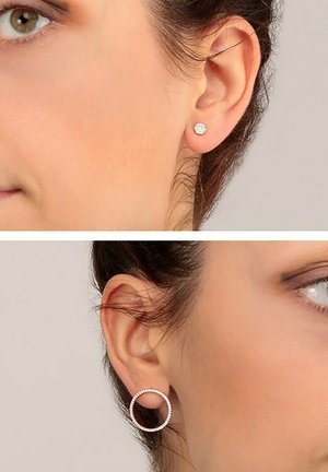 Silver studs och ringörhängen visas på en modell. Stiftet är runt med en texturerad yta; ringen har rhinestones som accentuerar och är i cirkulär form.