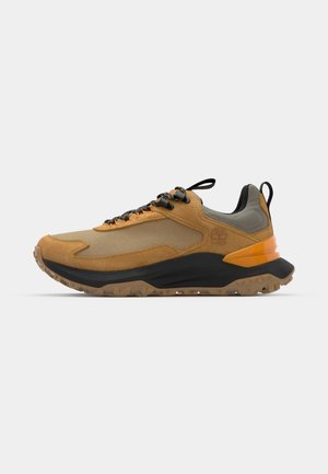 Chaussure de sport beige et grise avec une tige en mesh texturé, des accents orange vif, une semelle noire et des lacets durables pour un maintien sécurisé.