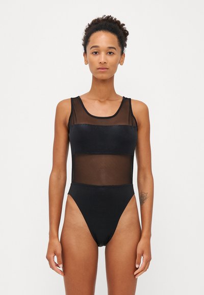 Schwarzer Badeanzug mit transparenten Mesh-Einsätzen. Merkmale einen runden Ausschnitt, einen hohen Beinausschnitt und strukturierte Nähte. Minimalistisches Design.