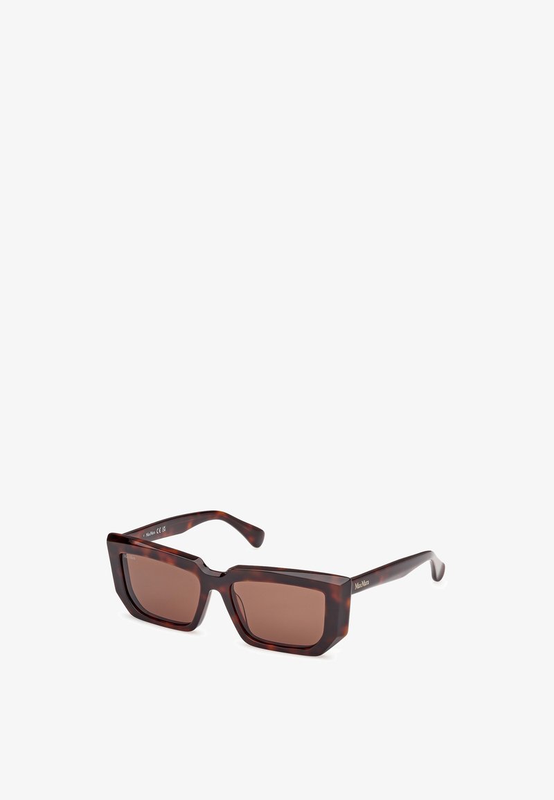 Óculos de sol quadrados com armação em tartaruga escura, lentes castanhas e hastes finas. Apresenta uma marcação discreta de lado e um design robusto.