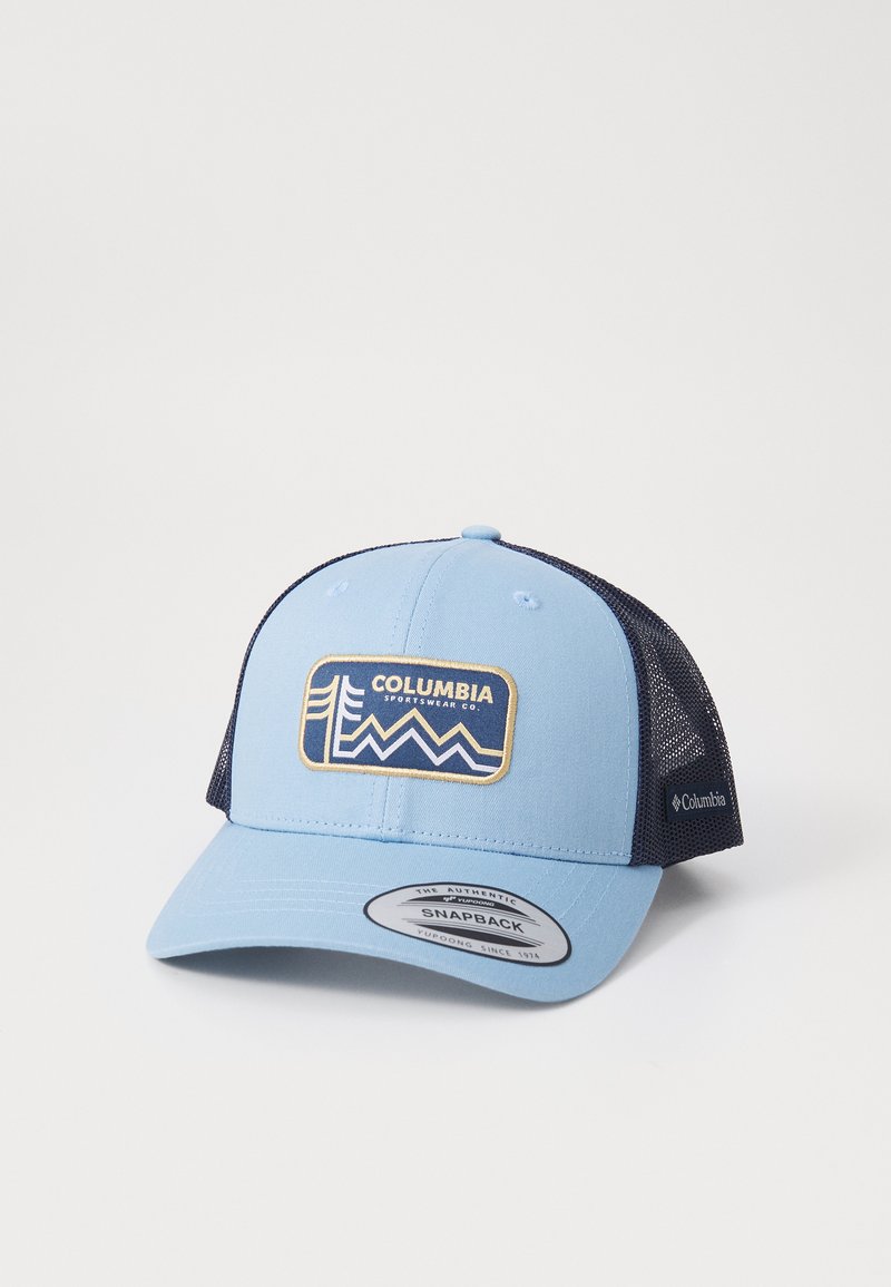 Zils snapback cepure ar tīkla tumši zilu aizmuguri, uz kuras ir taisnstūrveida Columbia logotips un kalnu-vaves dizains zeltītā un zilā krāsā.