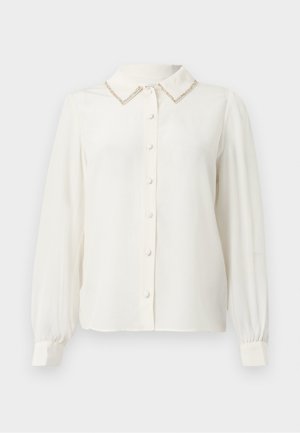 Hvid bluse med lange ærmer, krave, tekstureret gyldent accent på kraven og knaplukning foran. Blødt, glat stof.