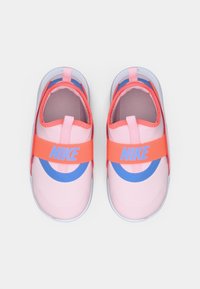 Scarpe Nike rosa con un design circolare blu, una fascia arancione con logo e una parte superiore texturizzata, progettate per una calzata slip-on.