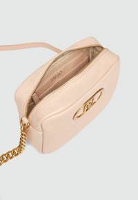 Helle rosa Lederhandtasche mit einem Reißverschluss, goldenen Beschlägen und einem geprägten Logo. Enthält einen Kettenriemen für Vielseitigkeit.