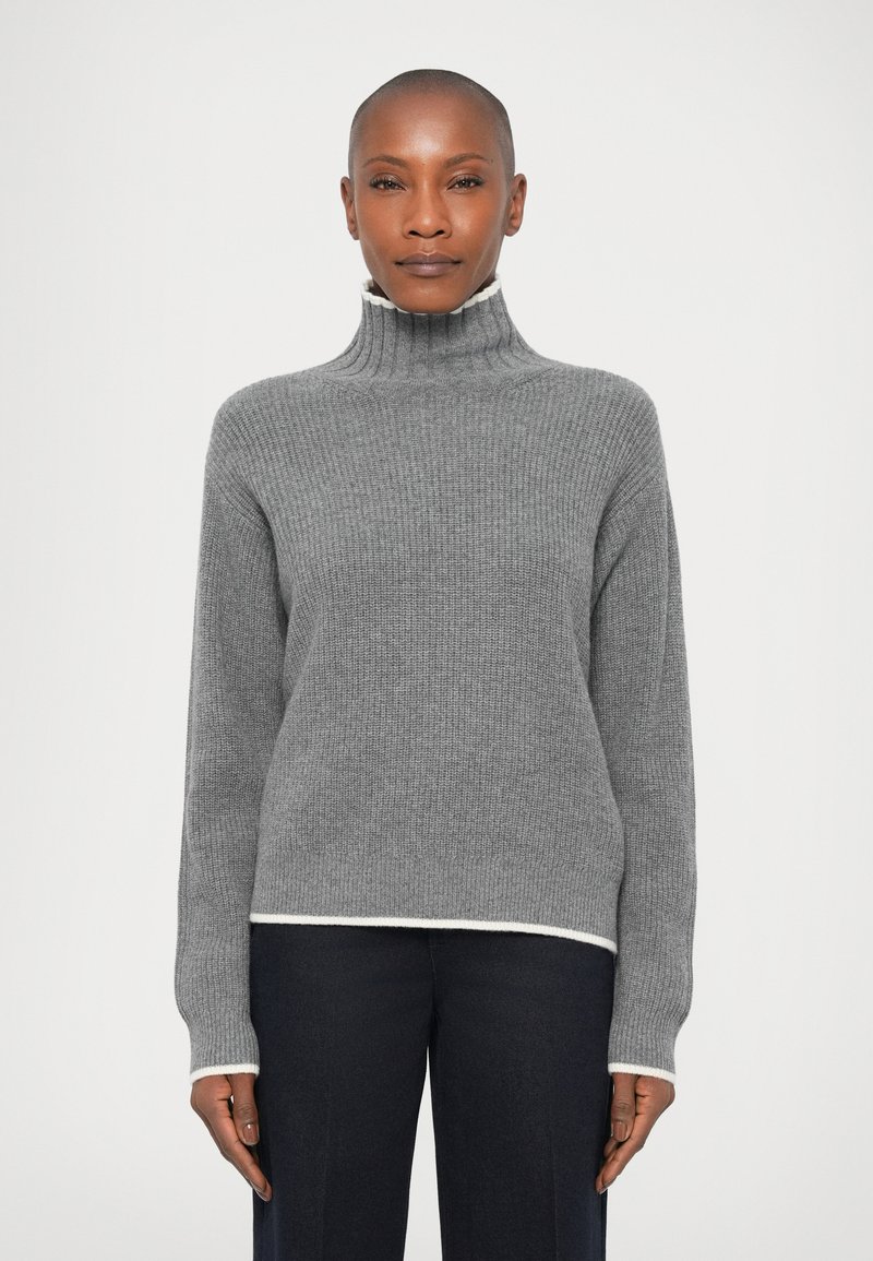 Pull col roulé gris à côtes avec un bord blanc à l'ourlet et aux poignets, présentant des manches longues et une coupe décontractée.