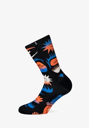 Czarne skarpetki z kolorowymi, abstrakcyjnymi wzorami w odcieniach pomarańczowego, niebieskiego i białego. Karbowany design oraz wygodne, amortyzowane podeszwy.