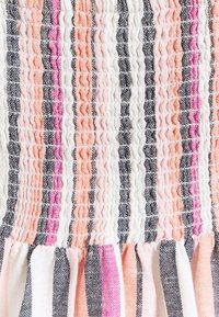 Strapless fabric detail featuring vertical stripes in pink, white, and black with gathered texture and a ruffled hem at the bottom.