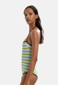 Pasiasty strój kąpielowy w oliwkowym zieleni i jasnoniebieskim, z ramiączkami na szyi i brązowym wykończeniem. Dopasowany krój z gładką teksturą.