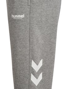 Grå sweatpants gjorda av mjukt, texturerat tyg; har Hummel-logotyp i vitt och två vita chevronränder på sidan.