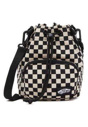 Petit sac à cordon noir et blanc à motif damier, avec poche zippée à l'avant et bandoulière noire réglable, logo Vans « Off The Wall » visible.