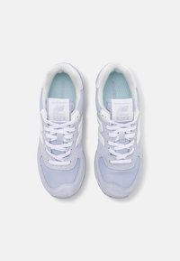 Ljusblå New Balance-sneakers med mesh- och mockamaterial, med vita accenter, vadderad krage och runda skosnören. Modell 574.