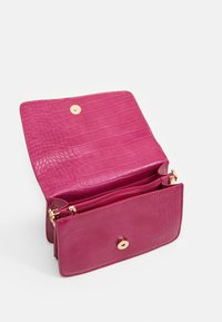 Pink crocodile-textured leather purse with a gold snap closure. Interior features a zip pocket and spacious compartments for organization.