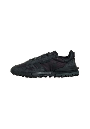 Sneaker nera a bassa cima con suola testurizzata, chiusura con lacci e tomaia in misto tessuto e pelle, progettata per un uso casual.