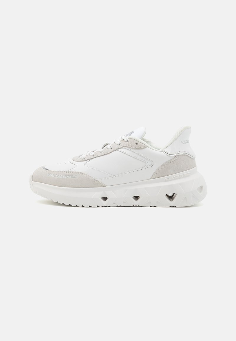 Sneaker blanche et gris clair présentant un mélange de textures lisses et en daim, un nez rond et une semelle épaisse triangulaire avec des découpes.