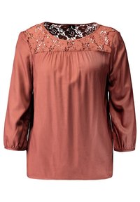 Blusa color ruggine con maniche lunghe, davanti plissettato e dettaglio in pizzo floreale sul collo. Tessuto liscio con lieve lucentezza.