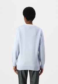 Ανοιχτό μπλε πλεκτό πουλόβερ με μακριά μανίκια και στρογγυλή λαιμόκοψη, που διαθέτει ριμπ μανσέτες και στρίφωμα. Λεία υφή, χαλαρή εφαρμογή.