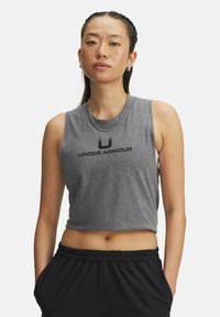 Šedý zkrácený top bez rukávů s černým logem "UNDER ARMOUR". Hladká bavlněná směs, bez rukávů a s kulatým výstřihem. V kombinaci s černými kalhotami.