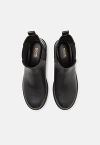Bocanci negri din piele cu panouri laterale elastice, tălpi plate din cauciuc și bucle pentru a fi ușor de încălțat. Textură netedă cu detalii de design minimaliste.