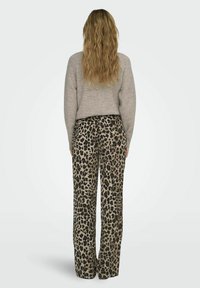 Leopardprint wijdbeenbroek met een beige achtergrond, met een gladde textuur en een hoge taille, gecombineerd met een lichtgrijze trui.
